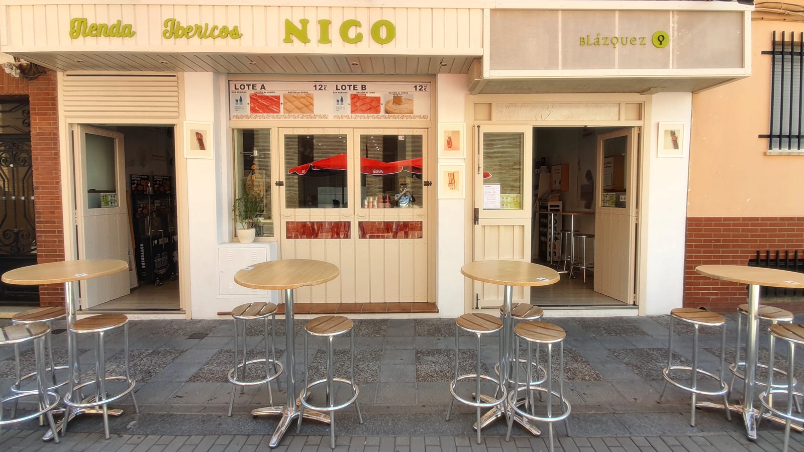 Entrada de la tienda Ibéricos Nico con mesas al aire libre